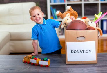 59157572 - boy taking donation box full with stuff for donate